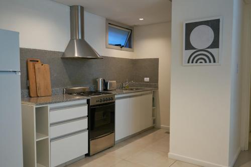 a kitchen with a sink and a stove top oven at CINCO - Departamentos in La Plata