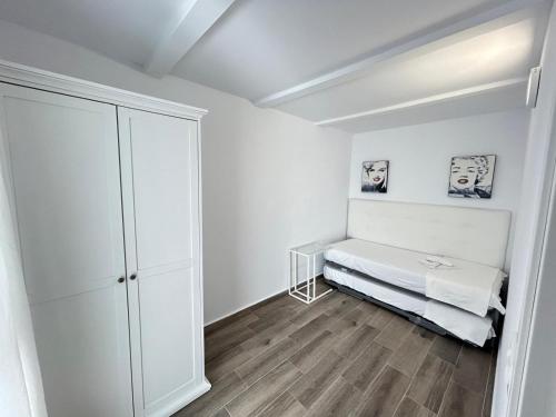 Dieses weiße Zimmer verfügt über ein Bett und einen Schrank. in der Unterkunft Apartamento Empul Barrosa Beach in Novo Sancti Petri