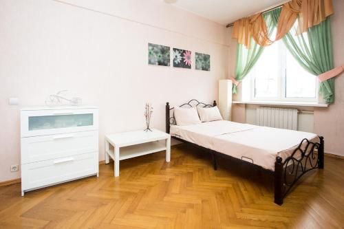 a bedroom with two beds and a dresser and a window at Apartlux on Karetnyy Ryad in Moscow