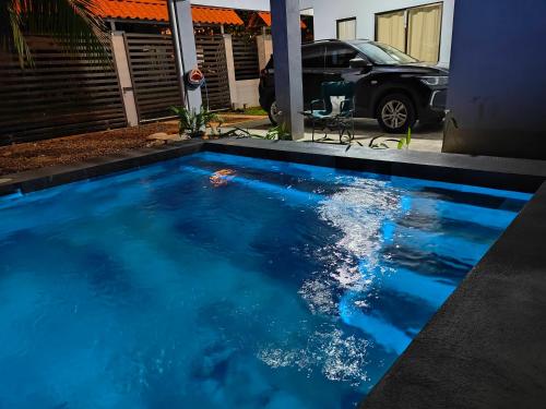 a swimming pool with blue water in front of a house at AJ House & Suites in Uvita