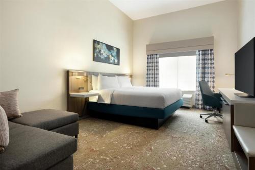 a hotel room with a bed and a desk at Hilton Garden Inn Riverhead in Riverhead