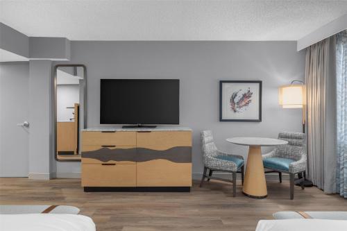 a living room with a television and a table at DoubleTree by Hilton Phoenix Midtown in Phoenix