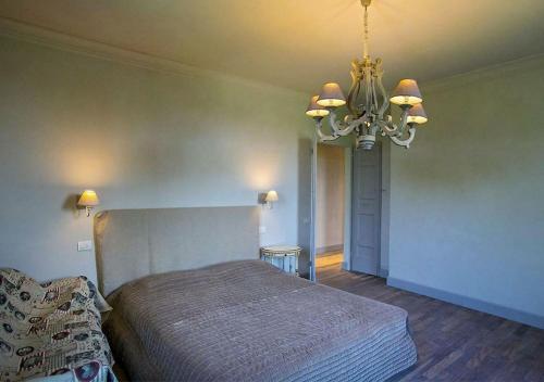 a bedroom with a bed and a chandelier at Villa Chloe in Potenza Picena