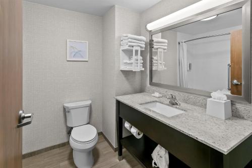 a bathroom with a toilet and a sink and a mirror at Hampton Inn & Suites Baltimore/Woodlawn in Baltimore
