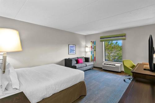 a hotel room with a bed and a couch at Hampton Inn & Suites Baltimore/Woodlawn in Baltimore