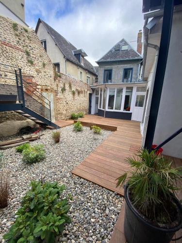 une arrière-cour avec une terrasse en bois et une maison dans l'établissement Les Flobarts - grande maison de famille en centre ville à 50m de la baie, à Saint-Valery-sur-Somme