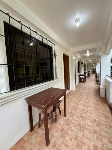 a hallway with a wooden table and a window at Marion Roos Hotel in Puerto Galera