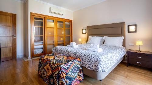 una camera da letto con un letto grande e un pavimento in legno di Greice Homes-Luxury 2 bed en-suite south facing & Golf view a Quarteira