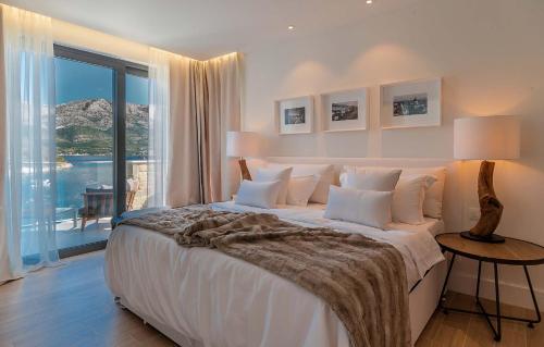 sypialnia z dużym łóżkiem i dużym oknem w obiekcie Spectacular Korcula Villa 4 Bedrooms Villa Korcula Grandeur Private Infinity Pool Stunning Sea Views Zrnovo w Korčuli