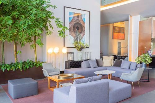 a living room with a blue couch and chairs at NH Collection Mexico City Santa Fe in Mexico City