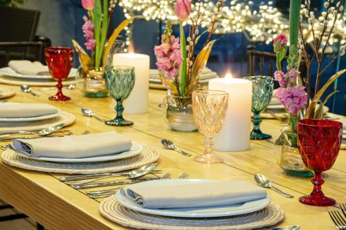 a table with plates and silverware and candles on it at NH Collection Mexico City Santa Fe in Mexico City