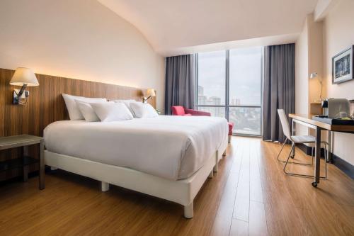 a hotel room with a large bed and a desk at NH Collection Mexico City Santa Fe in Mexico City