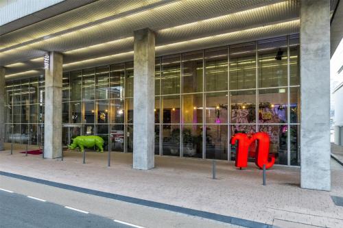a large glass building with red sculptures in front of it at nhow Rotterdam in Rotterdam