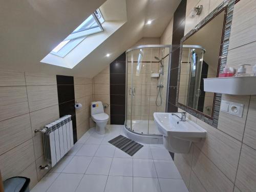 a bathroom with a sink and a toilet and a skylight at Bieszczadzki Dom Gościnny w Werlasie in Werlas