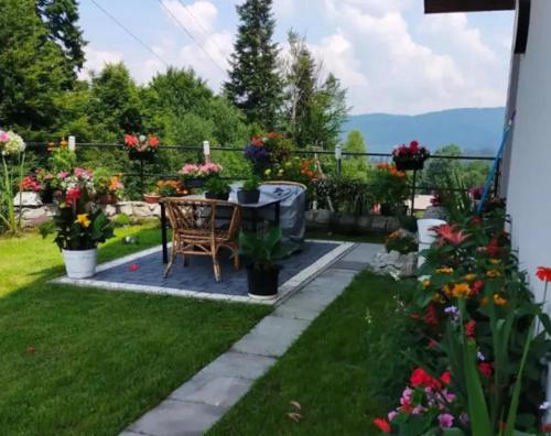 a garden with a table and chairs and flowers at Bieszczadzki Dom Gościnny w Werlasie in Werlas