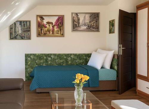 a bedroom with a bed and a vase of flowers on a table at Bieszczadzki Dom Gościnny w Werlasie in Werlas