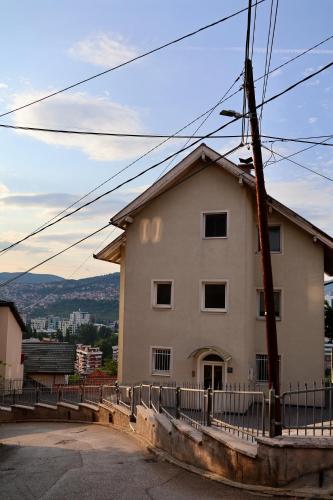 un grande edificio bianco con una recinzione accanto di Bella a Sarajevo