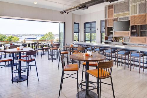a restaurant with tables and chairs and a large window at Hilton Garden Inn Providence in Providence