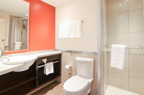 a bathroom with a toilet and a sink and a shower at Garden Court Nelson Mandela Boulevard in Cape Town