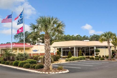 a hotel with two flags in a parking lot at Rodeway Inn & Suites Wilmington North in Wilmington
