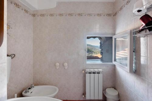 a bathroom with a white toilet and a window at Appartamenti La Fortezza in Corvara