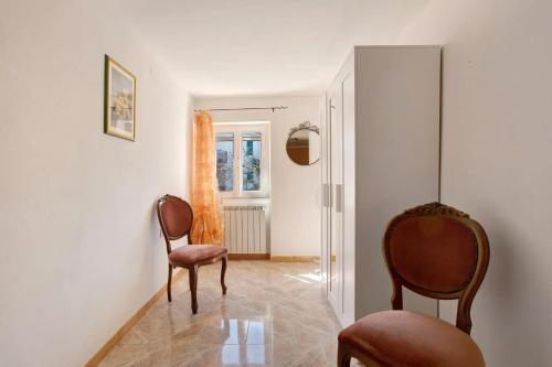 a living room with two chairs and a mirror at Appartamenti La Fortezza in Corvara