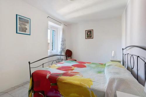 a bedroom with a bed with a colorful blanket on it at Appartamenti La Fortezza in Corvara