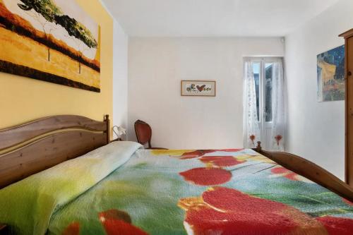 a bedroom with a bed with a colorful blanket on it at Appartamenti La Fortezza in Corvara