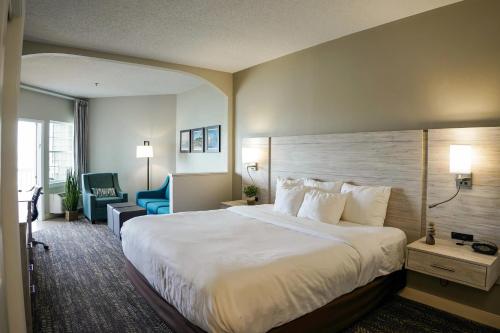 a hotel room with a large bed and a chair at Comfort Suites Chincoteague Island Bayfront Resort in Chincoteague