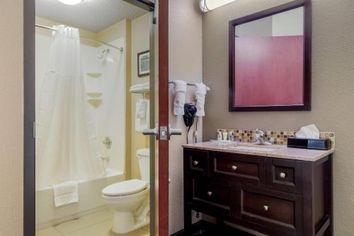 a bathroom with a sink and a toilet and a mirror at Comfort Suites Waco North - Near University Area in Waco