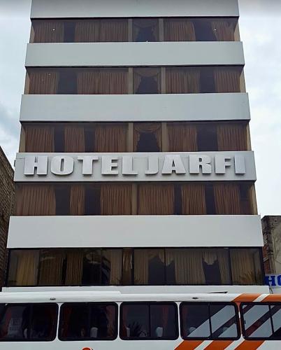 a bus is parked in front of a hotel at Hotel Jarfi in Hacienda El Recreo