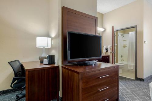 a hotel room with a television on a wooden dresser at Comfort Suites Waco North - Near University Area in Waco