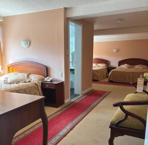 a hotel room with two beds and a table at Hotel Jarfi in Hacienda El Recreo