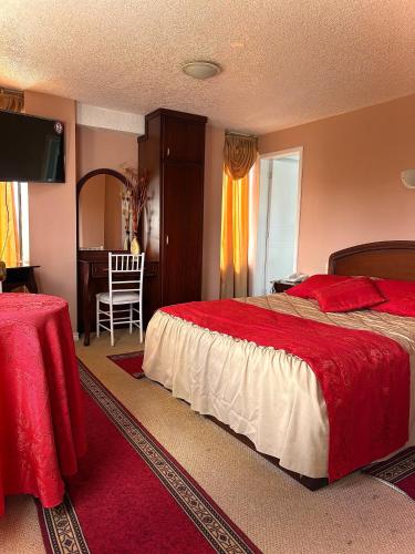 a bedroom with a bed and a table and a chair at Hotel Jarfi in Hacienda El Recreo