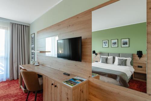 a hotel room with a bed and a desk at Pensiunea La Bella Vista in Poiana Negrii