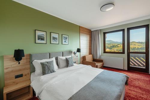 a bedroom with a large bed and a large window at Pensiunea La Bella Vista in Poiana Negrii