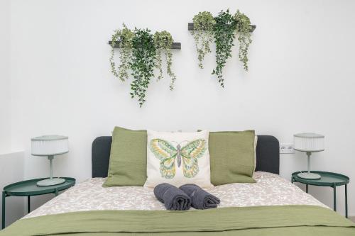 a bed with a butterfly pillow and some plants at City Nest Vilnius Oldtown in Vilnius