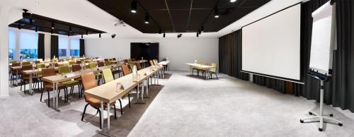 a conference room with tables and chairs and a projection screen at Park Inn By Radisson Brussels Airport in Diegem
