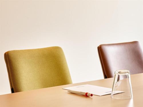 a laptop on a table with two chairs at Park Inn By Radisson Brussels Airport in Diegem