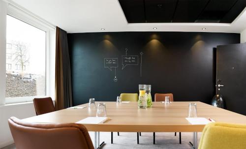 a conference room with a wooden table and chairs at Park Inn By Radisson Brussels Airport in Diegem