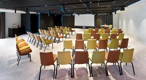 a group of chairs in a room with a screen at Park Inn By Radisson Brussels Airport in Diegem