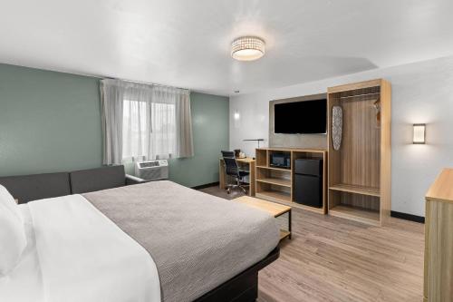 a hotel room with a bed and a flat screen tv at Quality Inn Atlanta Airport-Central in Atlanta