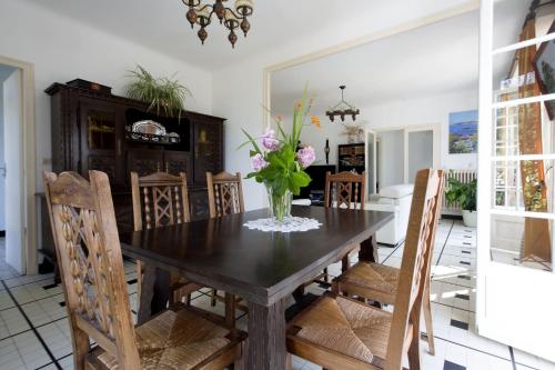 une salle à manger avec une table avec un vase de fleurs dans l'établissement Maison dans un écrin de verdure, à Biarritz