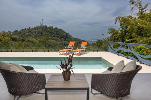 a patio with chairs and a swimming pool at Villa Buddha Belly OceanMountain top views in Quepos