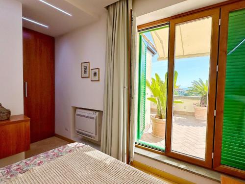 a bedroom with a bed and a large window at Terrazza da Sogno con Vista su Castello e Lago in Bracciano