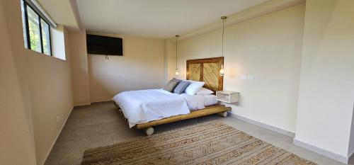 a bedroom with a bed and a tv on the wall at Villa Buddha Belly OceanMountain top views in Quepos