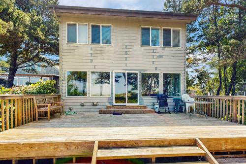 a house with a wooden deck in front of it at Beach Time Getaway in Lincoln City