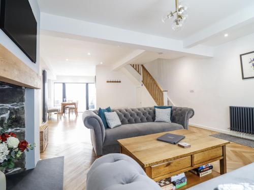 a living room with a couch and a table at Neptune Cottage in Conwy
