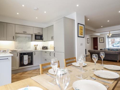 a kitchen and dining room with a table with wine glasses at Neptune Cottage in Conwy