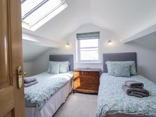two twin beds in a room with a window at Neptune Cottage in Conwy